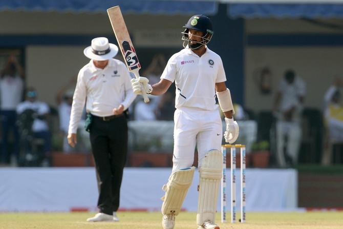 Cheteshwar Pujara is congratulated by Mayank Agarwal after completing 50.