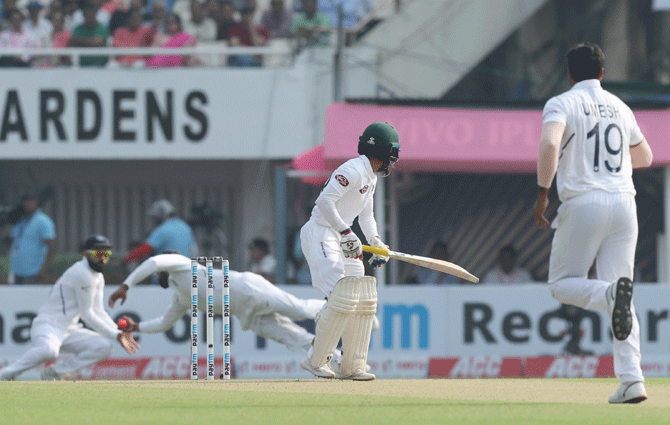 Rohit Sharma dives across to take the catch to dismiss Bangladesh captain Mominul Haque off Umesh Yadav's bowling on Day 1 of the 2nd Test on Friday