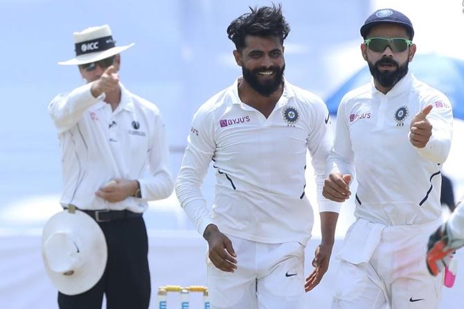 Ravindra Jadeja and Virat Kohli celebrate after Senuran Muthusamy is adjudged leg before wicket by umpifre Nigel Llong.