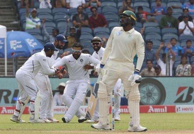  India's players rush to congratulate Rohit Sharma after he catches Senuran Muthusamy.