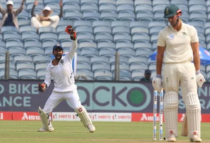 Wriddhiman Saha successfully appeals for the catch of Theunis de Bruyn.