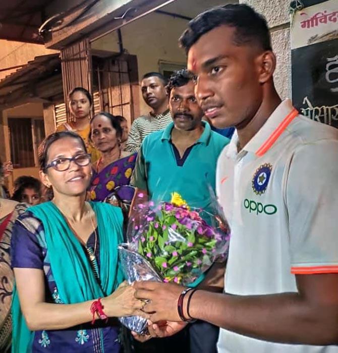 Atharva Ankolekar, right, is greeted by mother Vaidehi on his arrival in Mumbai on Sunday night.