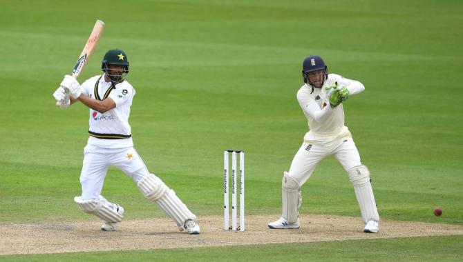 Shan Masood plays a cut shot as England's Jos Buttler watches