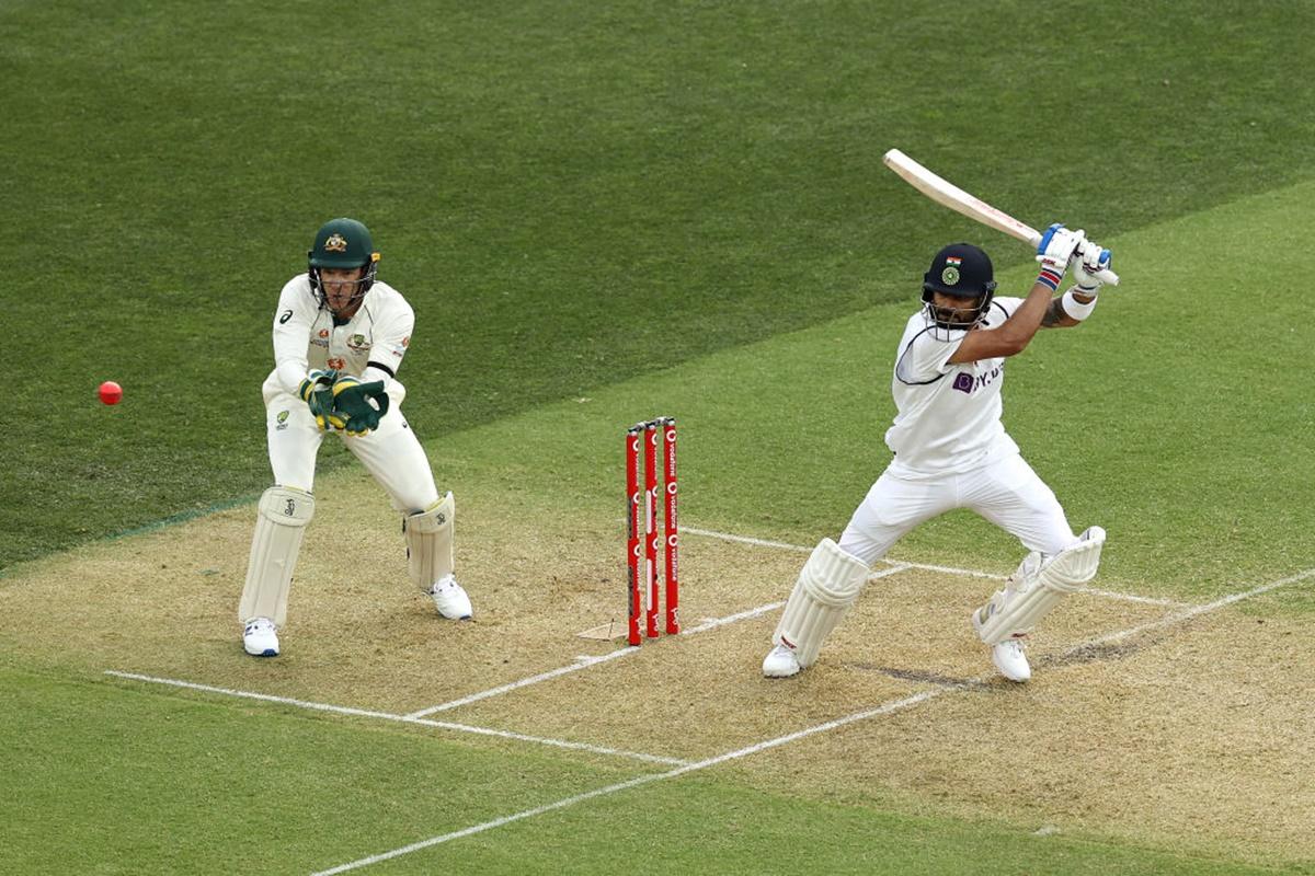 India's Virat Kohli sends the ball to the boundary as Australia's wicketkeeper Tim Paine looks during the second session on Day 1 of the first Test, at the Adelaide Oval