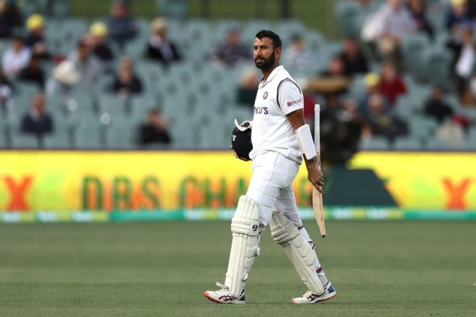 Cheteshwar Pujara walks off the field after being dismissed by Nathan Lyon.