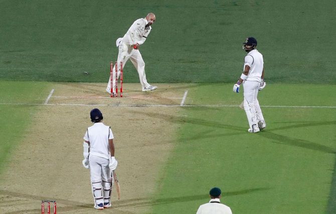 Nathan Lyon knocks the bails off the stumps after a throw from Josh Hazlewood to have Virat Kohli run-out
