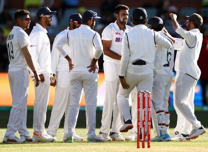 Ravichandran Ashwin celebrates with his teammates after dismissing Travis Head.