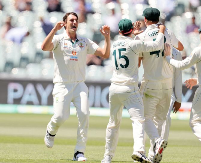 Pat Cummins celebrates with Cameron Green after the latter took a catch to dismiss Virat Kohli on Saturday