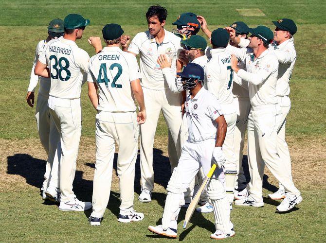 Mitchell Starc of Australia celebrates taking the wicket of Mayank Agarwal