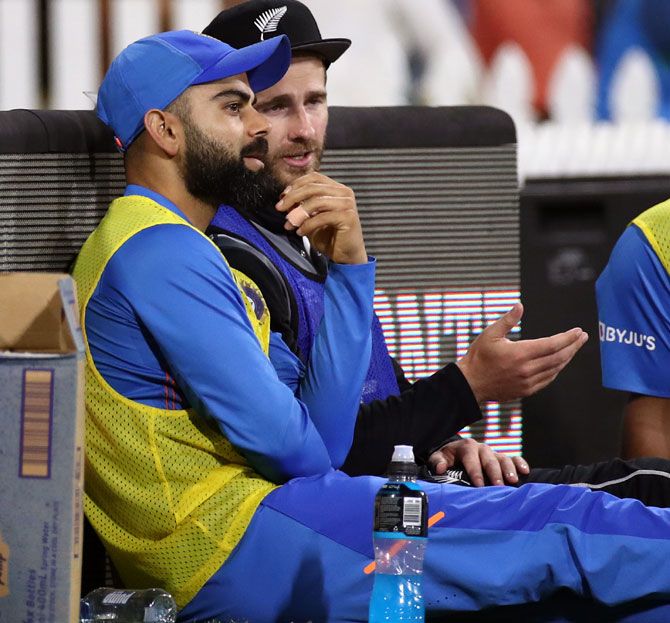 Virat Kohli and New Zealand skipper Kane Williamson, who both missed the match, chat on the sidelines during the fifth T20I