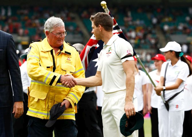 Australia captain Tim Paine speaks to Ku-ring-gai Fire Brigade Volunteer John Corry before the start of the third Test match in the series between Australia and New Zealand at Sydney Cricket Ground on Friday