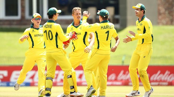 Connor Sully celebrates the fall of an India wicket with his Australia teammates.