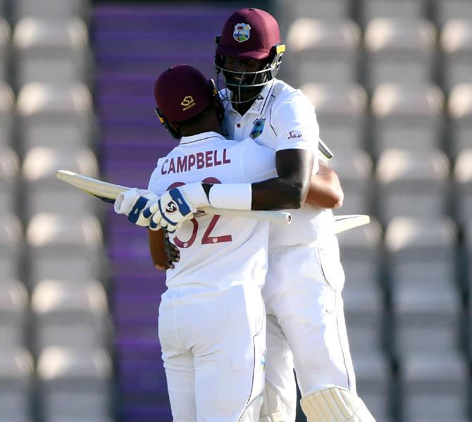 West Indies captain Jason Holder, right, celebrates with John Campbell after winning the 1st #RaiseTheBat Test match 