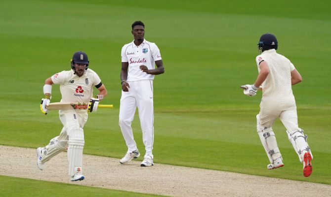 England's Rory Burns and Dom Sibley run between the wickets as West Indies pacer Alzarri Joseph looks on