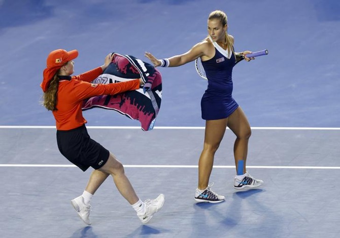 A ball kid hands Dominika Cibulkova of Slovakia a towel during her women's singles final against Li Na of China at the Australian Open 2014 tennis tournament. 