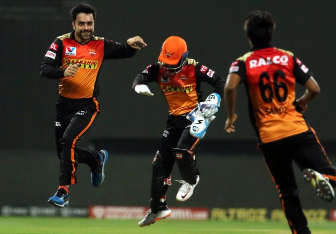 Rashid Khan, left, celebrates with team-mates after running out Moeen Ali
