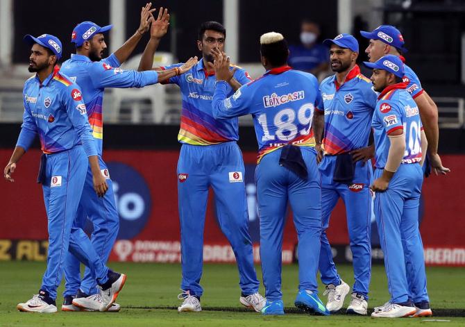 Delhi Capitals players celebrate after Ravichandran Ashwin, centre, dismisses Royal Challengers Bangalore opener Devdutt Padikkal.