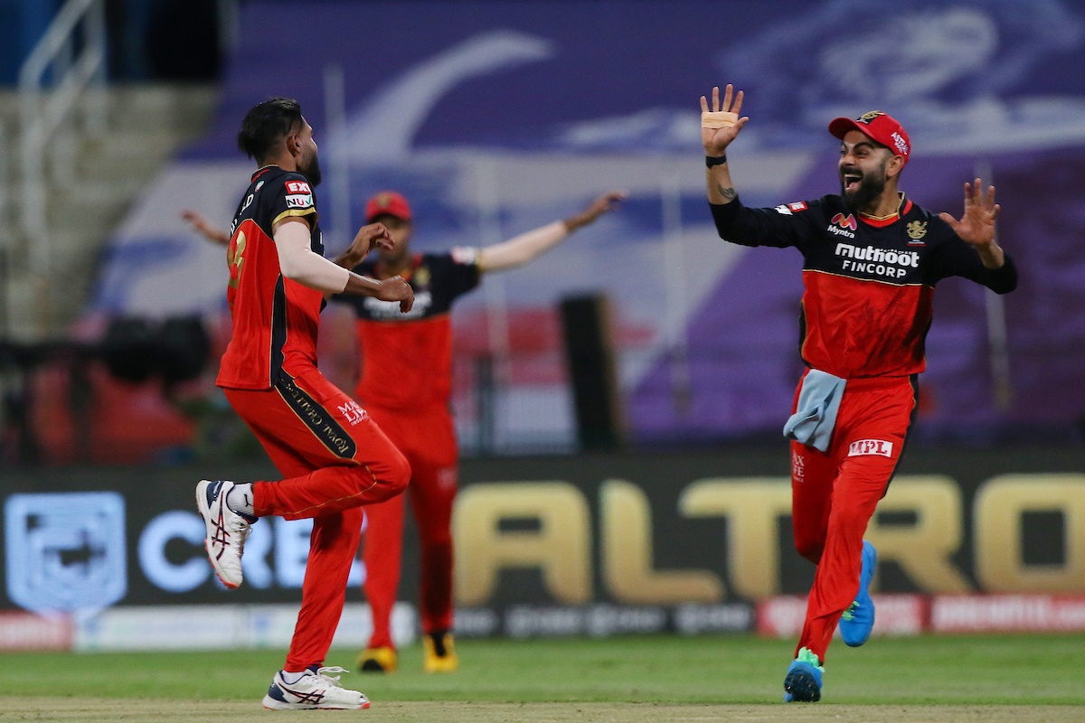 Pacer Mohammed Siraj, left, celebrates with skipper Virat Kohli after having Tom Banton caught A B de Villiers.