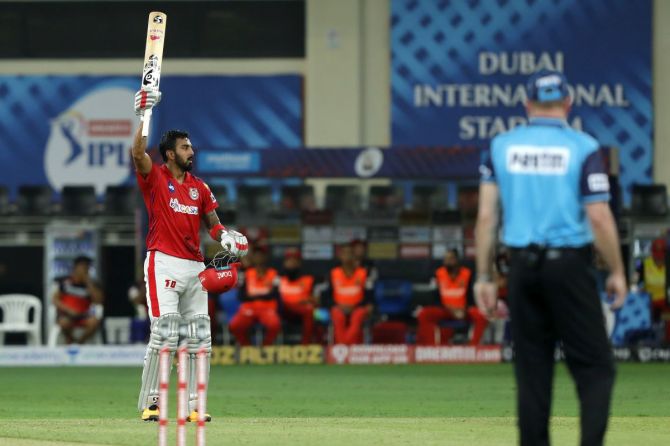 K L Rahul raises his bat to celebrate scoring a hundred against Royal Challengers Bangalore in Thursday's IPL match in Dubai
