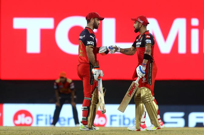 Glenn Maxwell and Virat Kohli celebrate a four during their partnership.