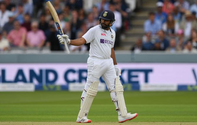 Rohit Sharma raises his bat after reaching 50.