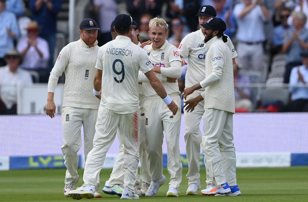 Sam Curran celebrates with teammates after dismissing Virat Kohli.