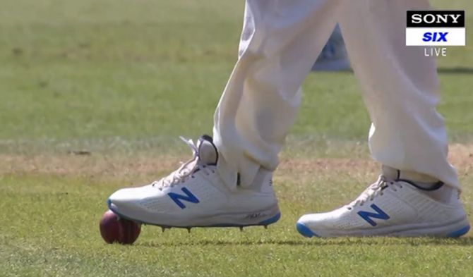 An England player uses his spikes to trap the ball.