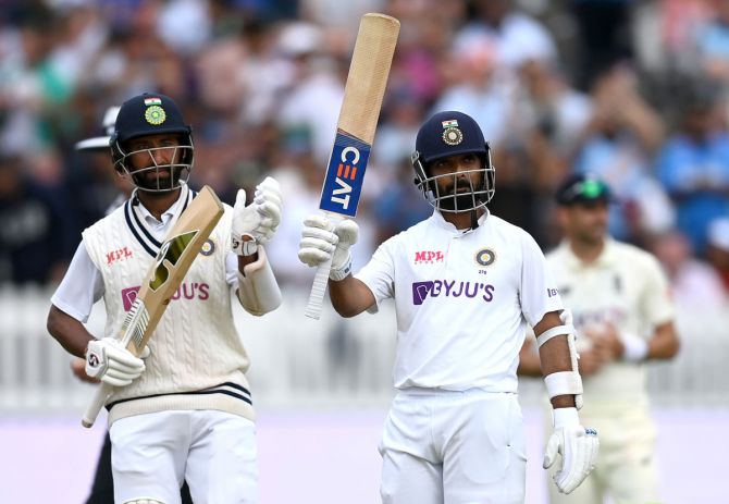 India's Ajinkya Rahane raises his bat after posting a half century, as Cheteshwar Pujara applauds, during Day 4 in the second Test against England, at Lord's Cricket Ground, on Sunday. 