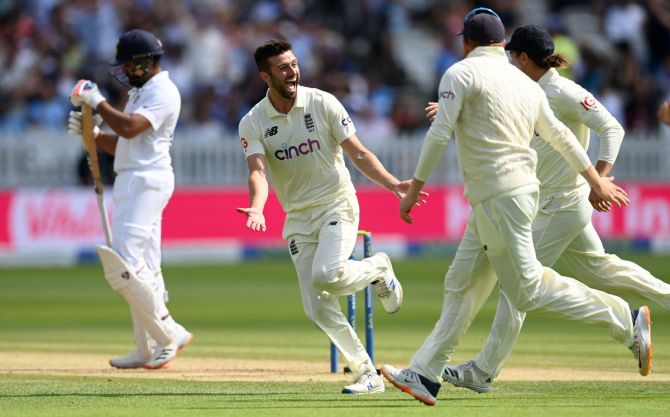 Rohit Sharma reacts as Mark Wood celebrates with his England teammates after picking his second wicket in the morning session of Day 4.