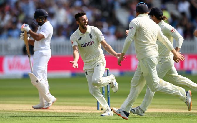 Rohit Sharma reacts as Mark Wood celebrates with his England teammates after picking his second wicket in the morning session on Day 4