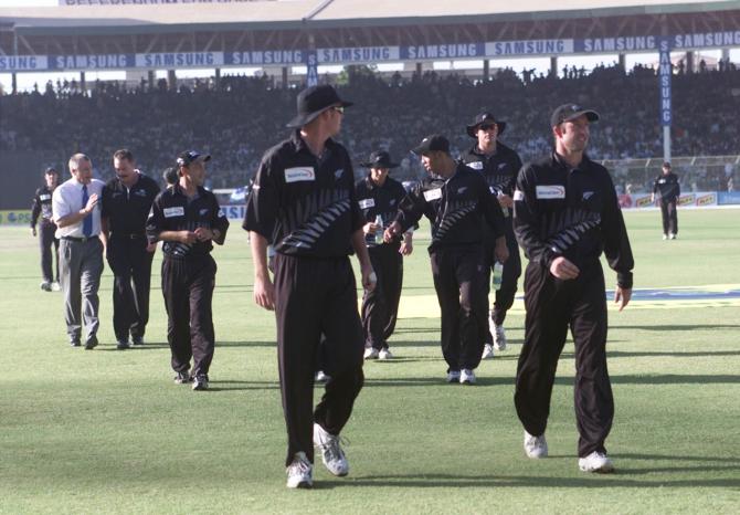 New Zealand's players leave the ground after spectators throw empty bottles on one of their players during their first One-Day International in Karachi on April 21, 2002.