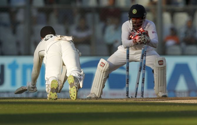 India's wicketkeeper Wriddhiman Saha runs out New Zealand's Tom Blundell in the second innings on Day 3 of the second Test, in Mumbai, on Sunday.