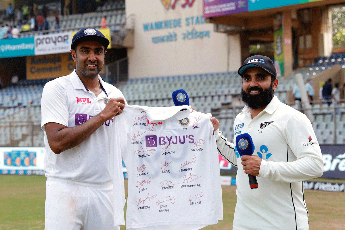 India's Ravichandran Ashwin presents Ajaz Patel a jersey signed by Indian players as a mark of respect to the Kiwi bowler on his ten-wicket haul in an innings during the 2nd Test in Mumbai.