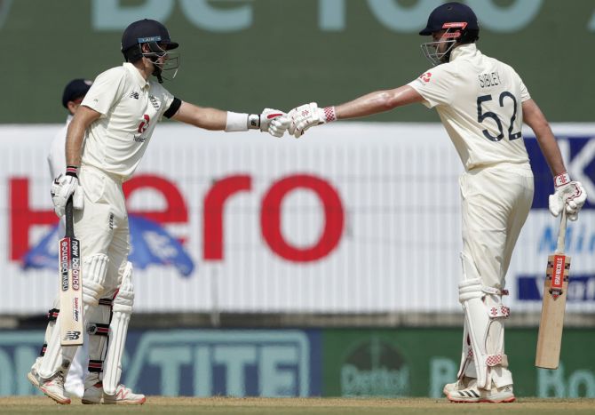 England's Dominic Sibley and Joe Root celebrate their 50-run partnership during Day 1 of the first Test against India, at the M A Chidambaram stadium, in Chennai, on Friday.