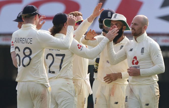 England's players celebrate the wicket of Rohit Sharma
