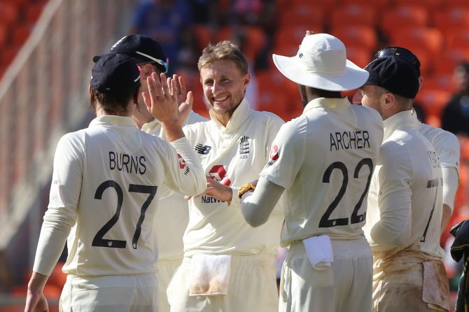 Joe Root is congratulated by his England teammates after dismissing Jasprit Bumrah and ending India's first innings.