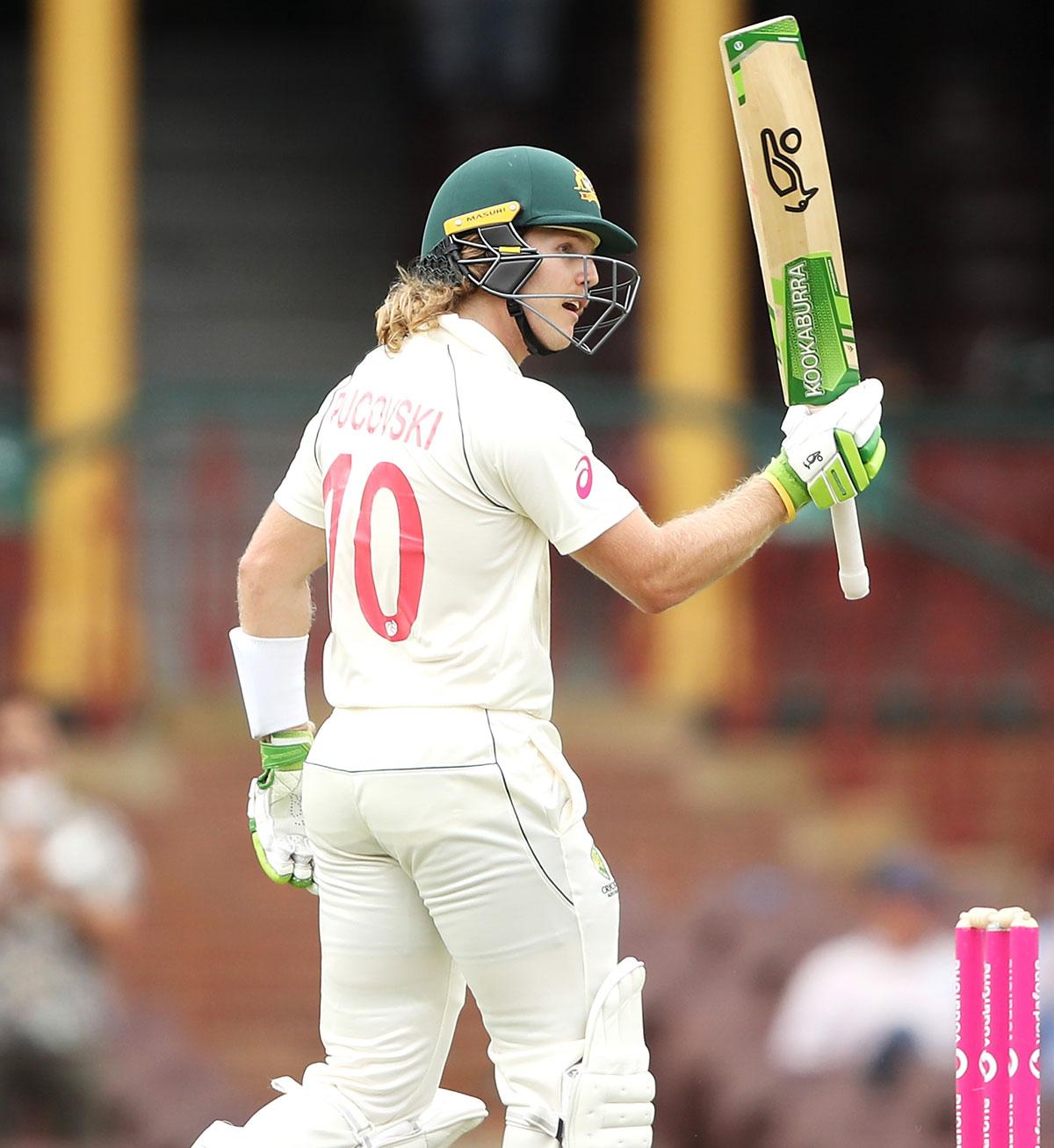 Australia opener Will Pucovski waves to the dressing room after completing his half century 