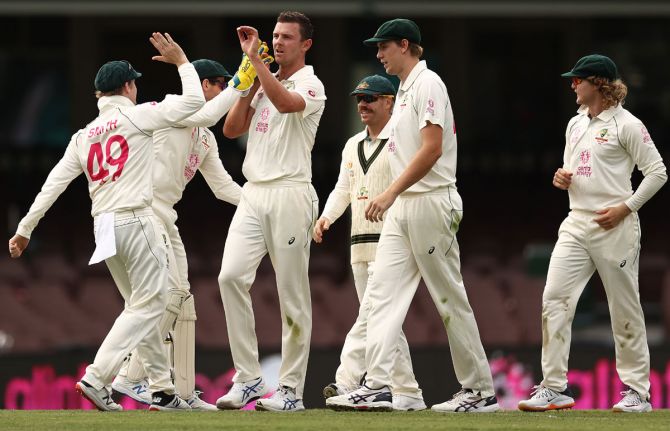 Josh Hazlewood celebrates after taking a catch to dismiss Rohit Sharma of India off his own bowling