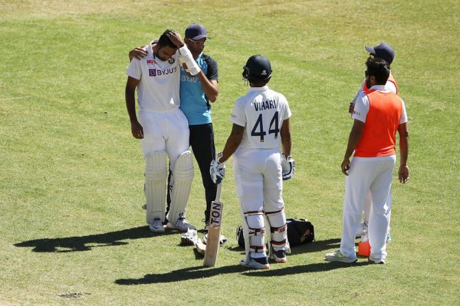 Ravichandran Ashwin receives attention after being struck by a short ball in the ribs