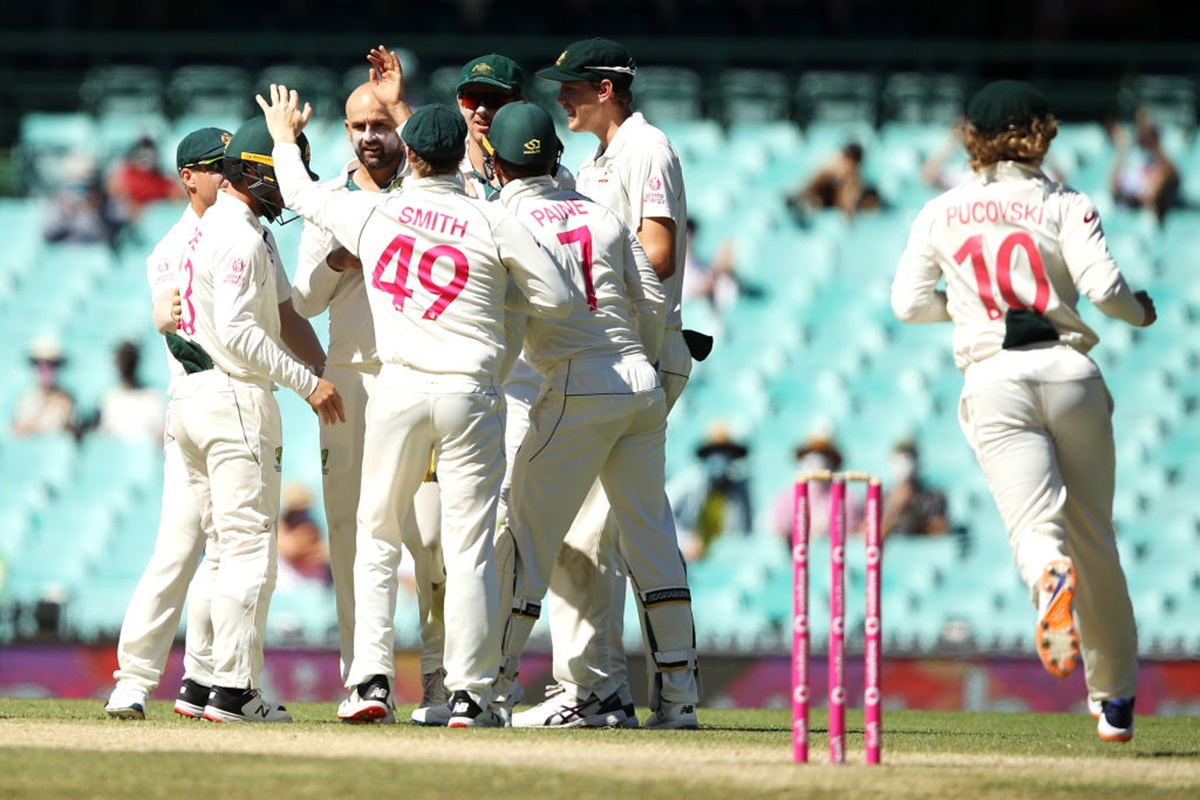 Nathan Lyon celebrates with his teammates after taking the wicket of Ajinkya Rahane.