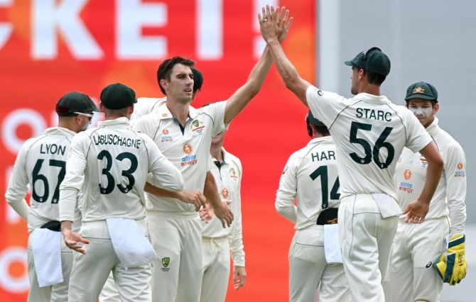 Australia pacer Pat Cummins celebrates with Mitchell Starc after dismissing India opener Shubman Gill during Day 2 of the fourth Test, at the Gabba, in Brisbane, on Saturday.