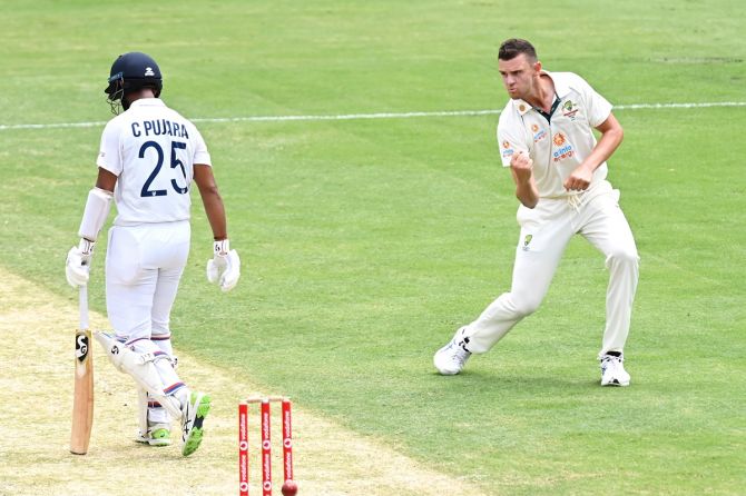 Australia pacer Josh Hazlewood celebrates taking the wicket of India's Cheteshwar Pujara in the morning session on Day 3 of the Gabba Test in Brisbane