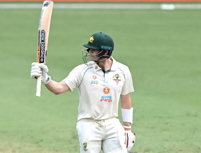 teve Smith waves to the dressing room after getting to 50