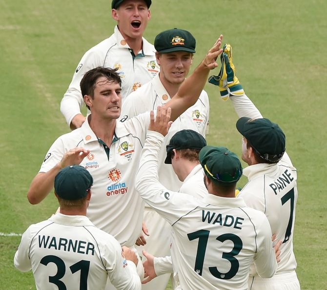Australia pace Pat Cummins is congratulated by teammates after dismissing Rohit Sharma early on Day 5.