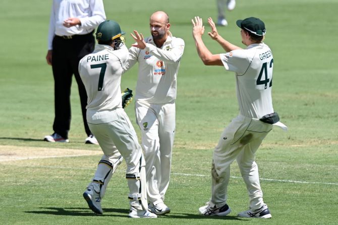 Nathan Lyon celebrates with Tim Paine after taking the wicket of Shubman Gill.
