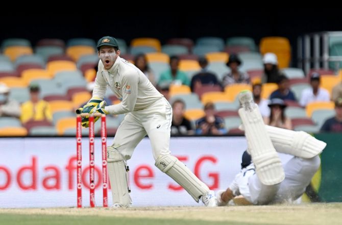 Australia's wicketkeeper Tim Paine reacts as Cheteshwar Pujara makes his ground in time.