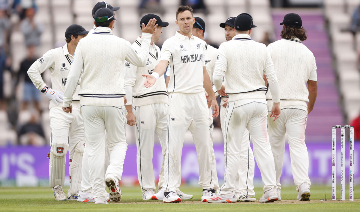 New Zealand pacer Trent Boult celebrates with teammates after dismissing Cheteshwar Pujara. 