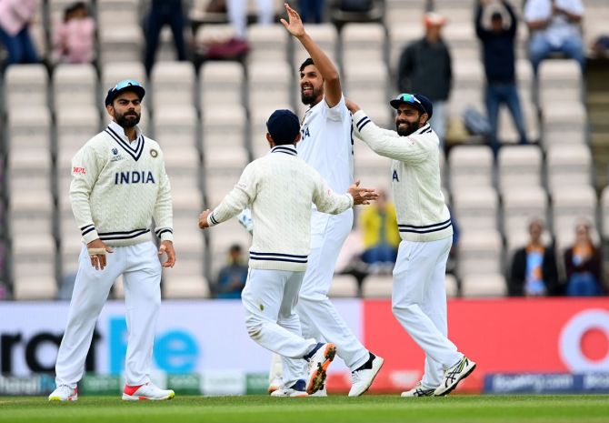Ishant Sharma celebrates with teammates after taking the wicket of Henry Nicholls