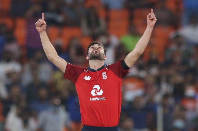 Mark Wood raises his arms in triumph after dismissing India opener Shikhar Dhawan 