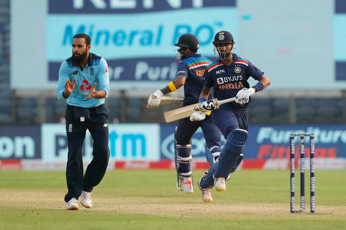 Adil Rashid watches anxiously as Krunal Pandya and K L Rahul steal a quick single 